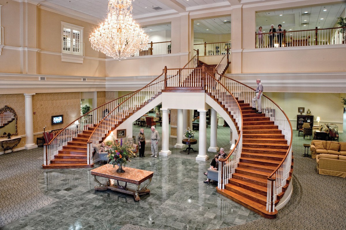 A luxurious hotel lobby featuring a grand staircase and elegant chandelier.