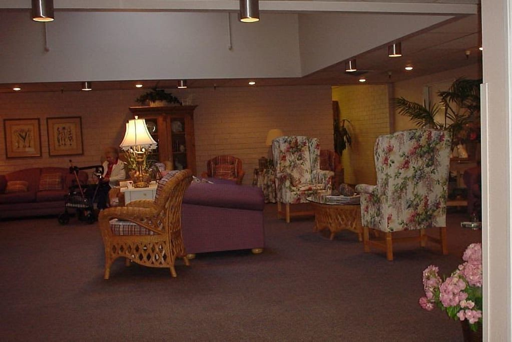 A cozy living room area with sofas, chairs, and a lamp.