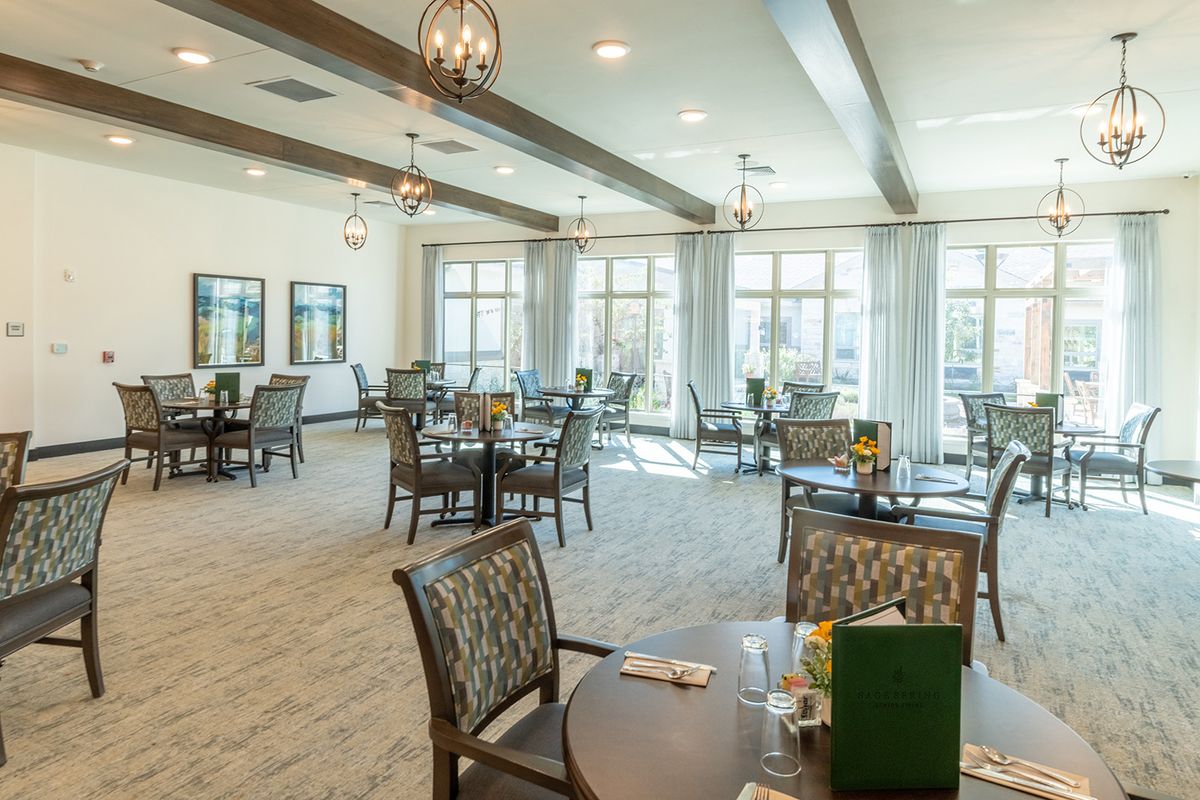 A bright and modern dining area with multiple tables and chairs.