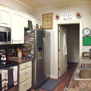 A modern kitchen with stainless steel appliances and white cabinetry.