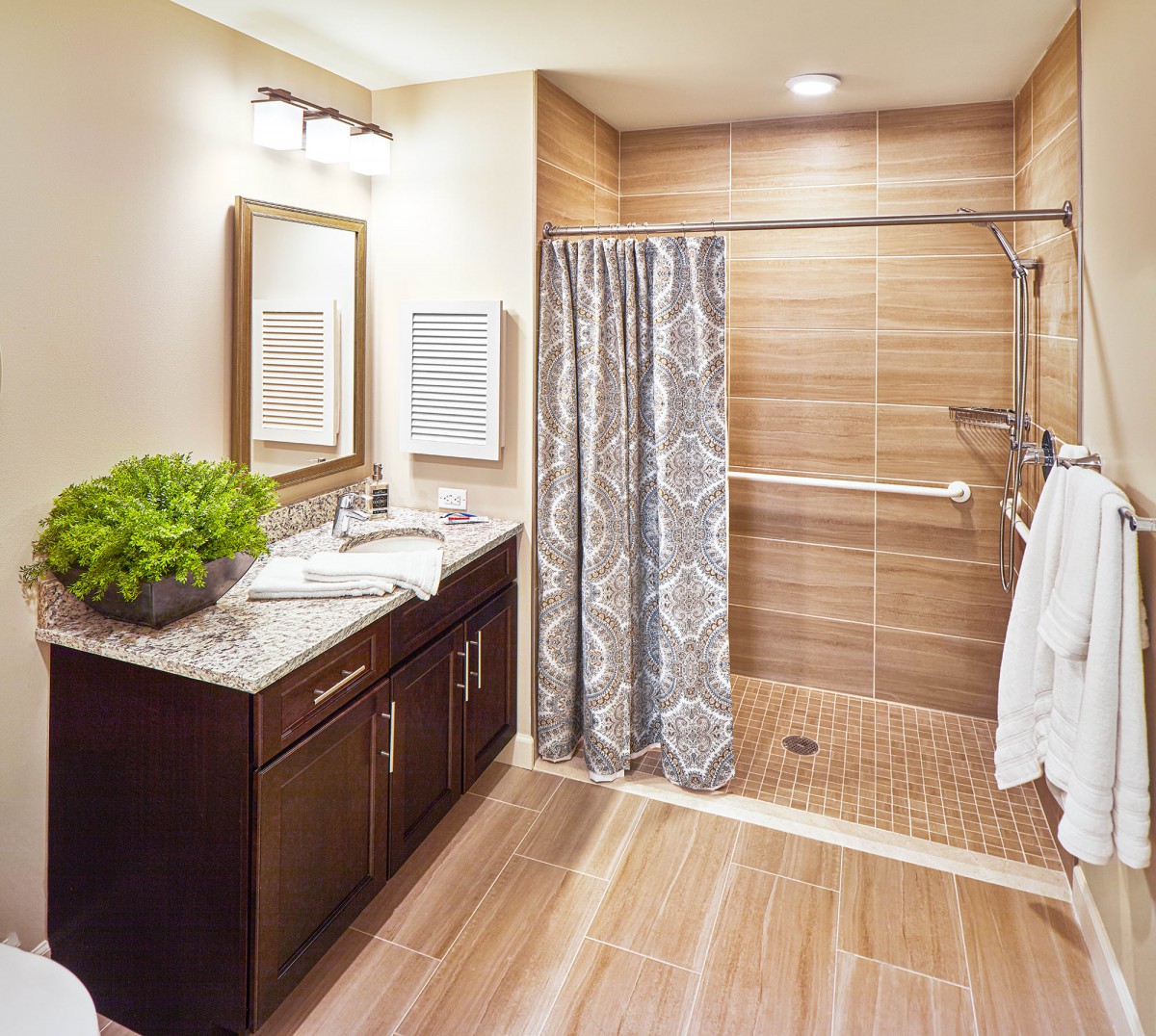 A modern bathroom with a wooden tile shower, stylish vanity, and decorative plants.