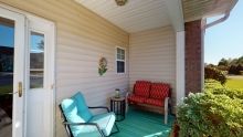 A cozy porch with colorful seating and a small table.