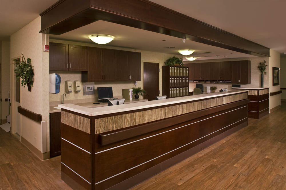 An office reception area with a long desk and wooden decor.