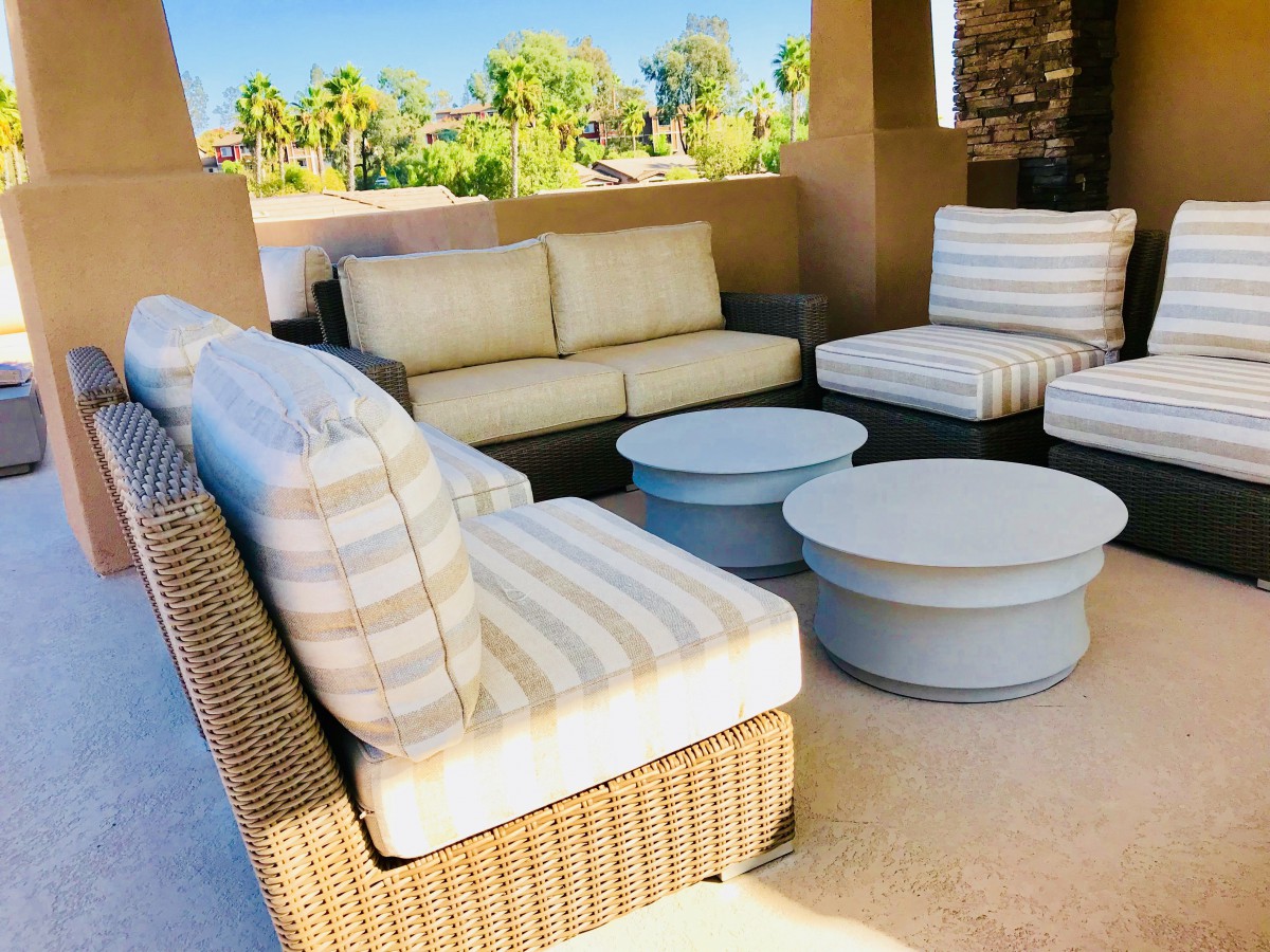 Outdoor patio seating area with sofas, chairs, and tables.