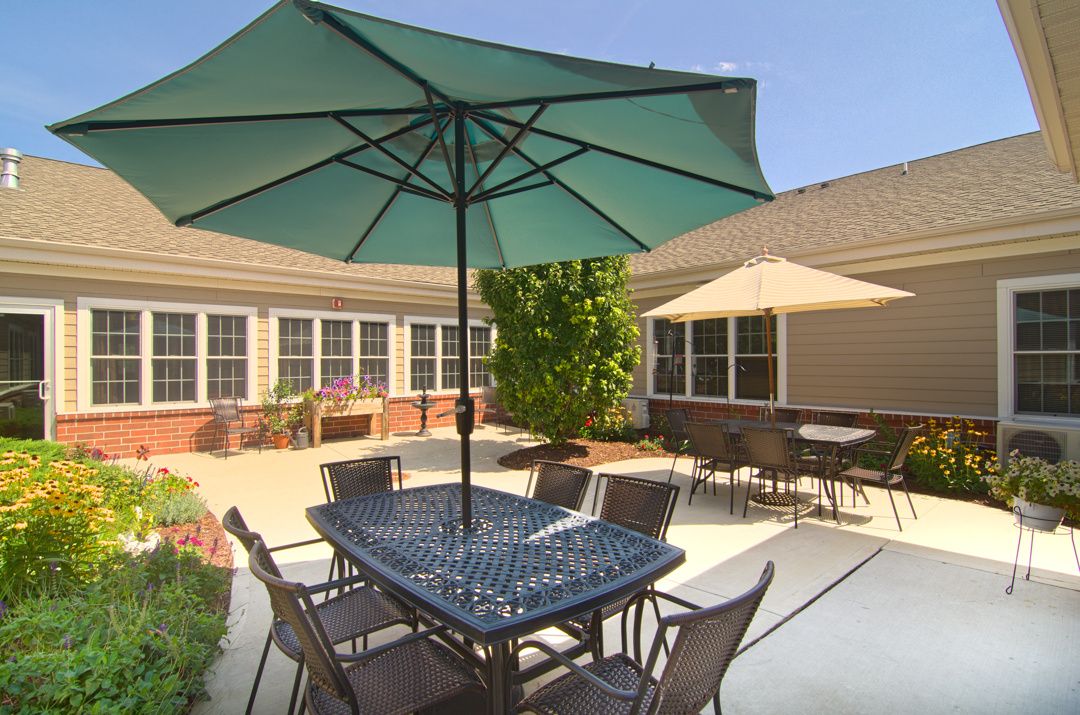 A sunny patio with outdoor seating featuring tables and umbrellas.