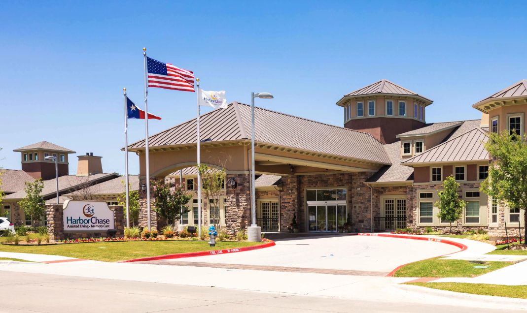 A modern building with a prominent entrance and American flags displayed outside.
