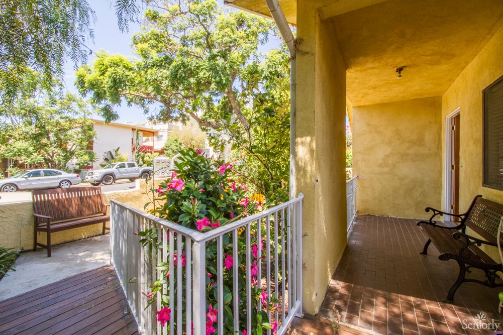A sunny balcony adorned with vibrant flowers and a metal railing.