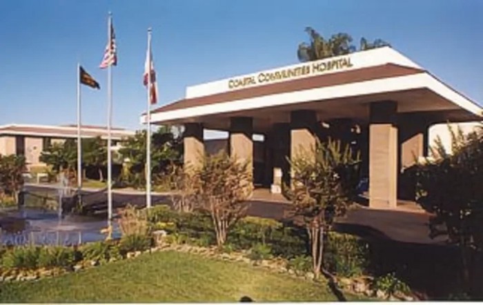 Entrance of a community hospital with flags and landscaping.