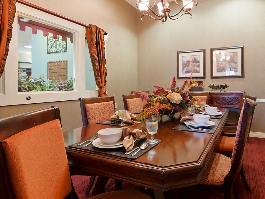 A warmly decorated dining room featuring a table set for a meal, with elegant decor and soft lighting.