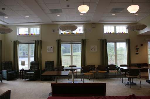 A cozy lounge area featuring comfortable seating, large windows, and a welcoming atmosphere.