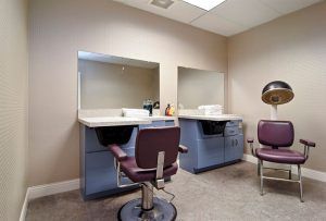 A beauty salon interior with two styling stations and chairs.