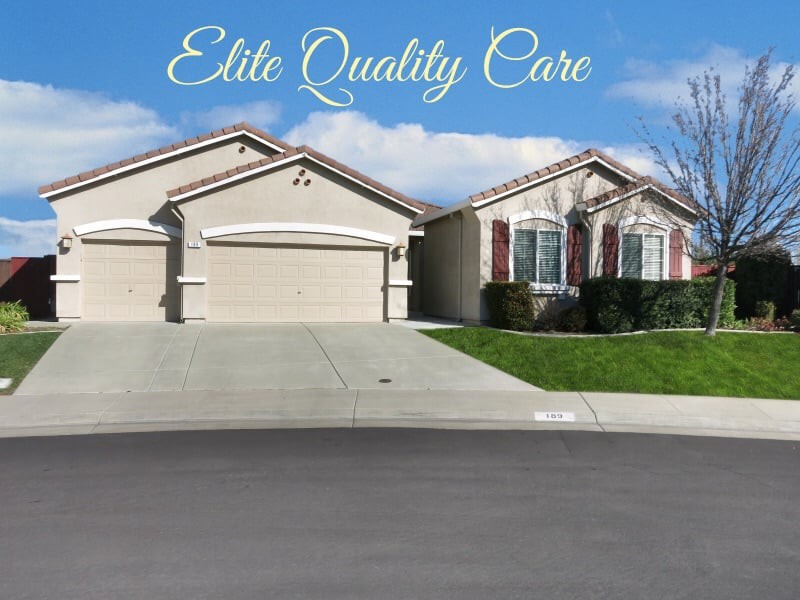 Suburban home with a well-maintained exterior and driveway under a clear blue sky.