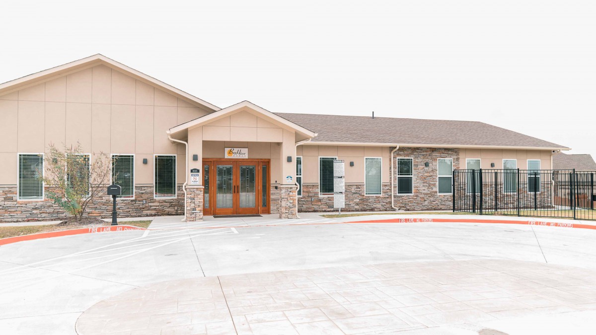 Exterior view of a building with a prominent entrance and stone facade.