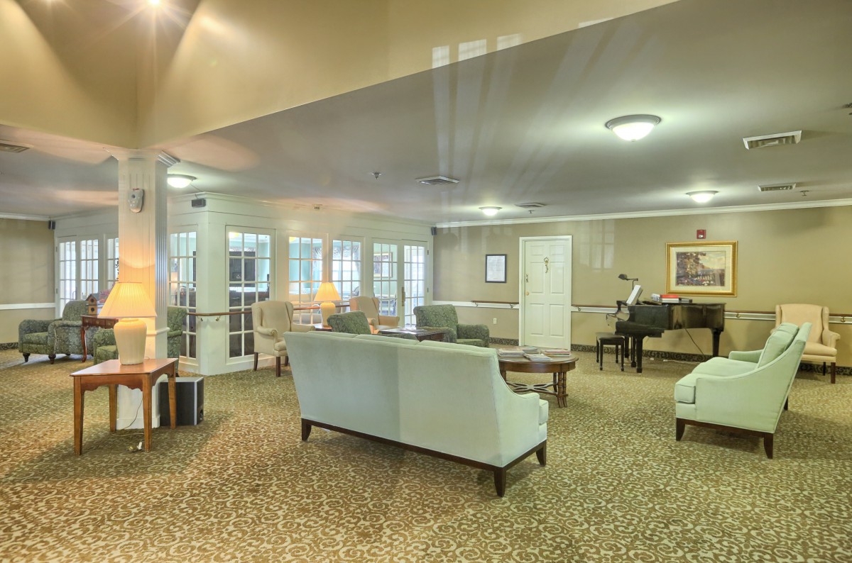 A cozy lounge area featuring sofas, a piano, and warm lighting.