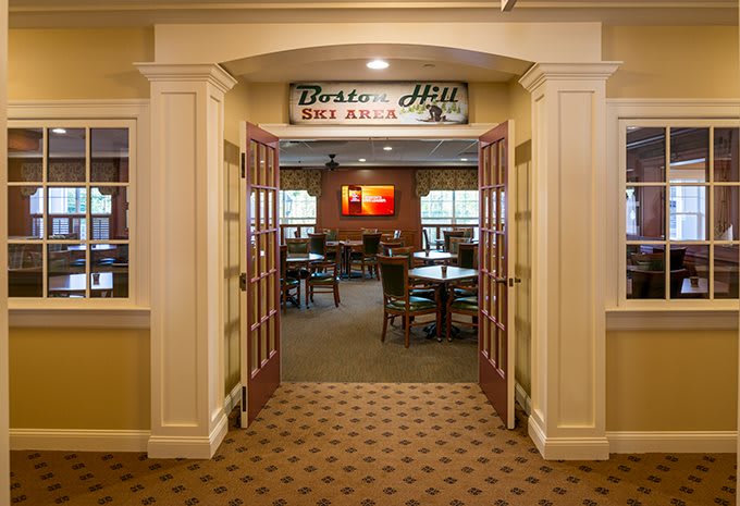 An inviting entrance to a restaurant dining area with tables and chairs visible inside.