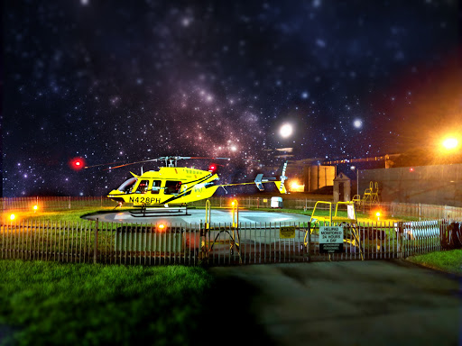 A vibrant yellow helicopter sits under a starry night sky, blending urban transportation with the vastness of space.