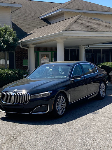 A luxurious black BMW 7 Series sedan parked in front of a building.