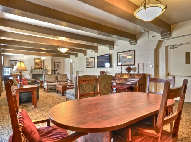 A cozy lounge area featuring wooden furniture and ceiling beams.