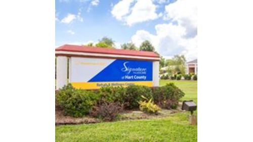 Entrance sign of Signature HealthCARE at Port County, showcasing the facility in a landscaped setting.