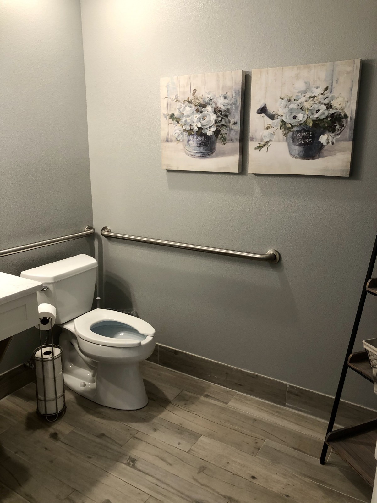A modern bathroom with wall art and safety railings.