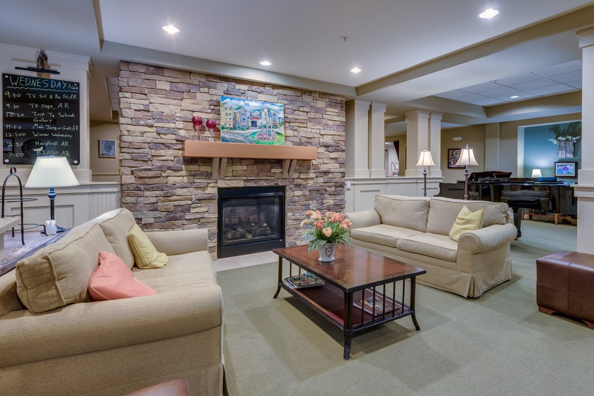 A cozy living room with a stone fireplace and comfortable seating.