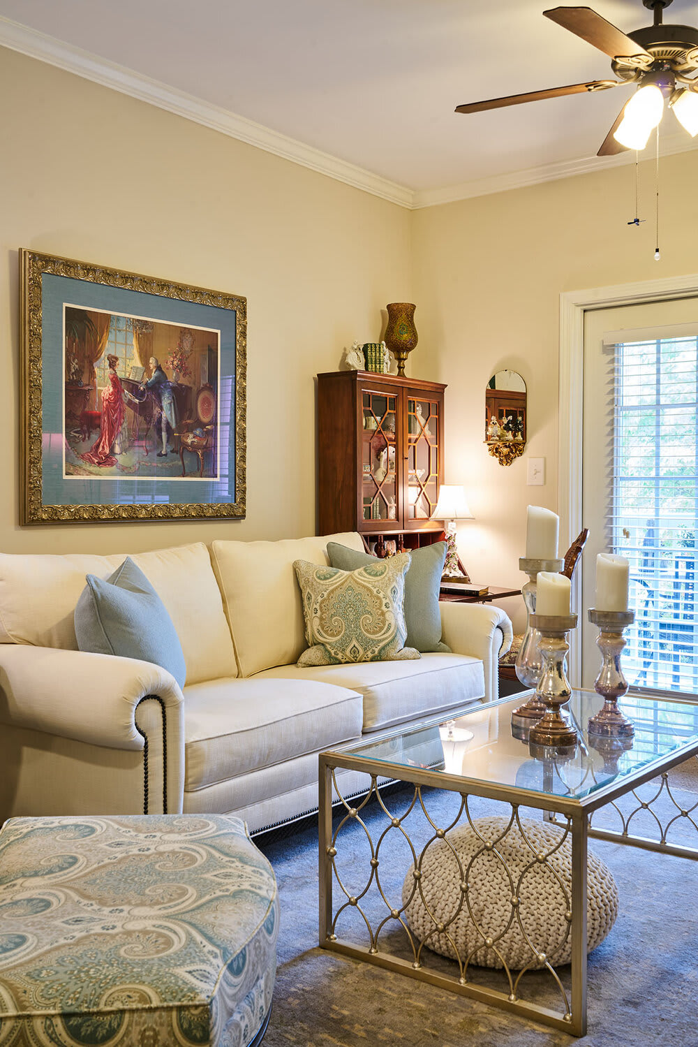 A cozy living room with traditional decor, featuring a comfortable sofa and elegant artwork.