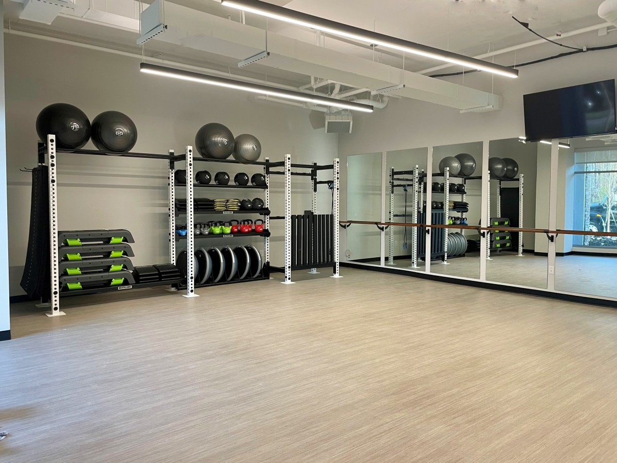 A spacious fitness studio equipped with exercise gear and mirrors.