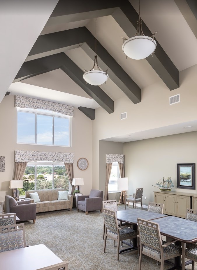 A spacious, modern living room with high ceilings and large windows.