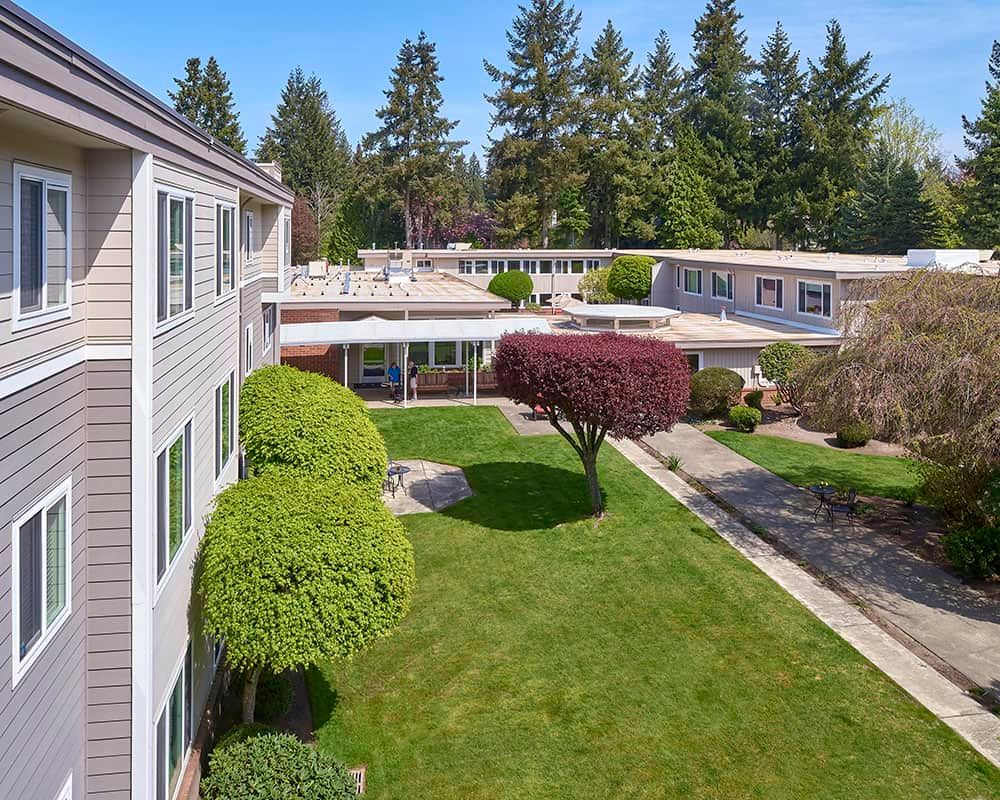 Aerial view of an apartment complex with a well-maintained lawn and trees.