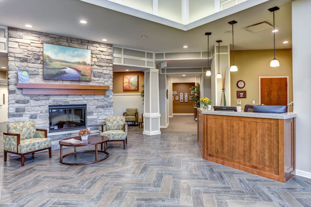 A modern lobby area with a reception desk and seating near a fireplace.