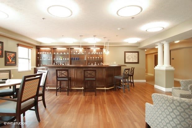 A cozy and elegant bar interior with wooden flooring and stylish furniture.