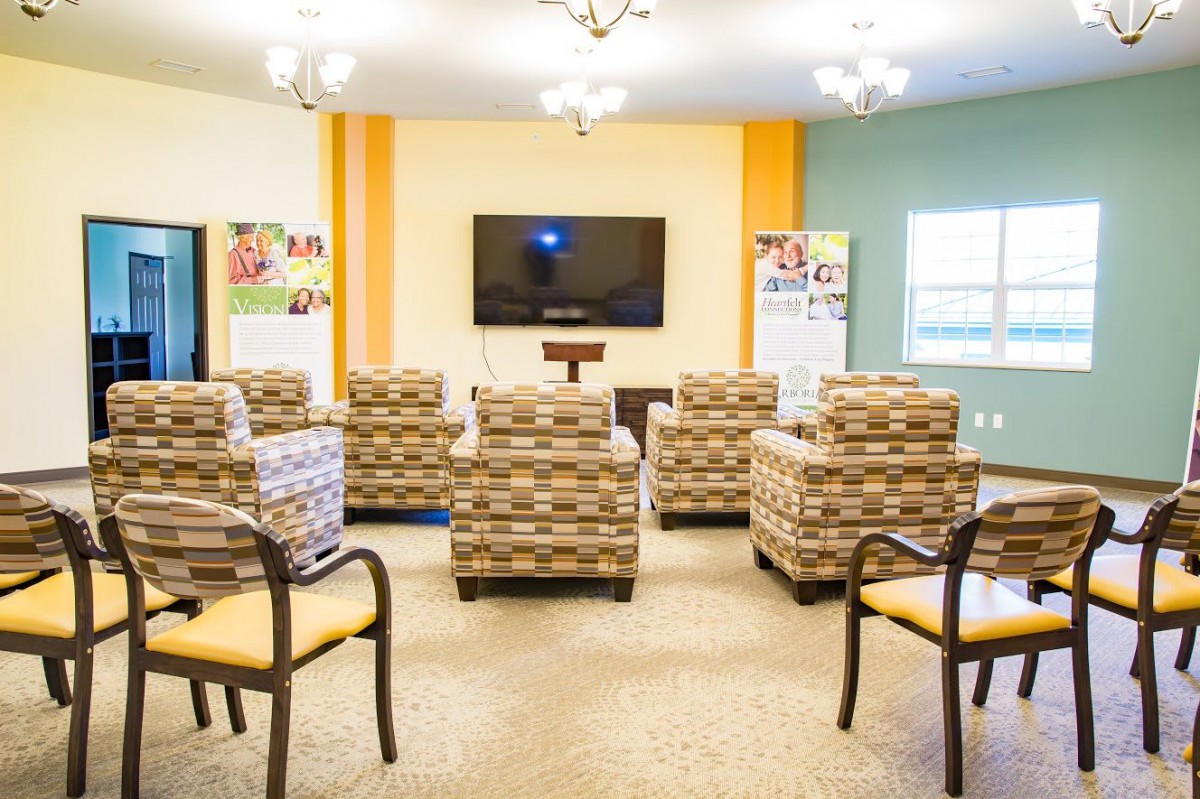 A cozy living room setup with patterned chairs facing a wall-mounted television.
