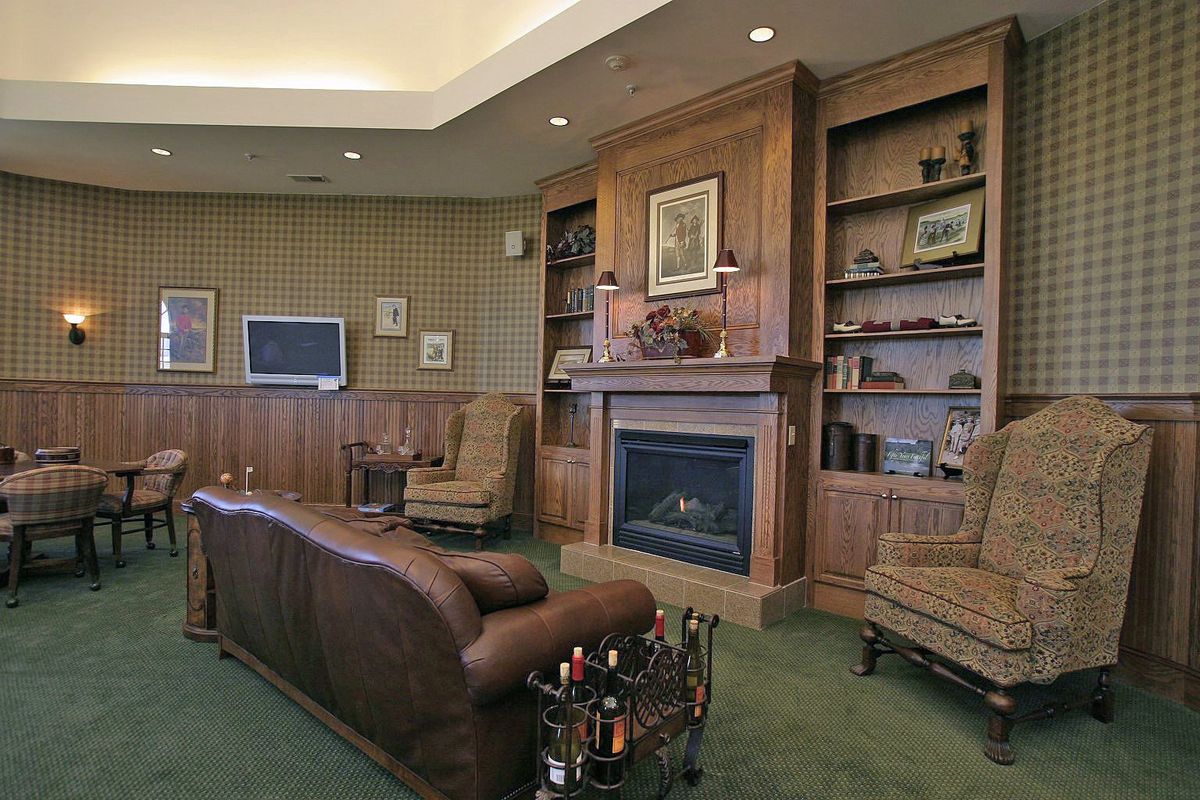 A cozy living room with a fireplace, bookshelves, and classic furniture.