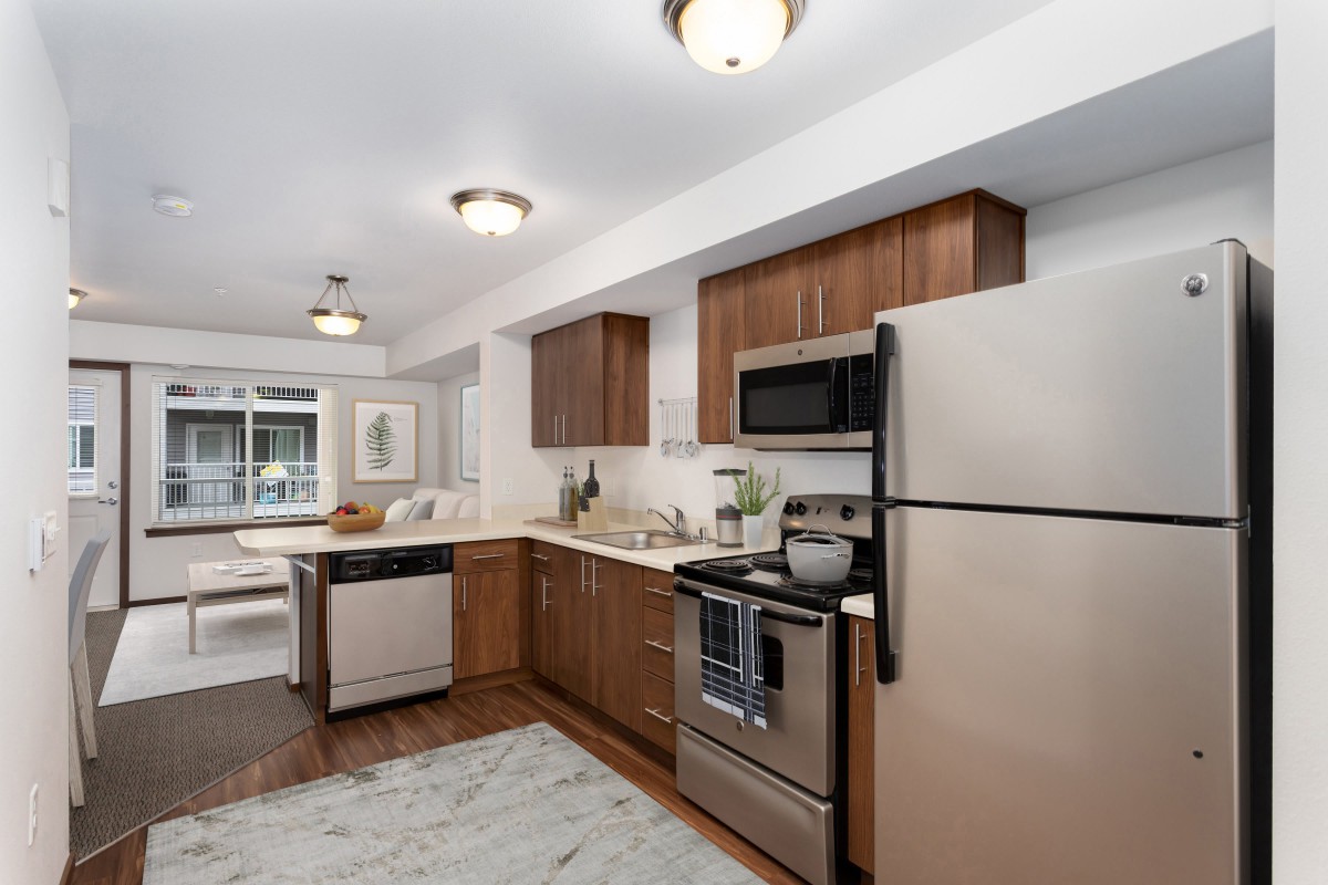 A modern kitchen with stainless steel appliances and wooden cabinets.