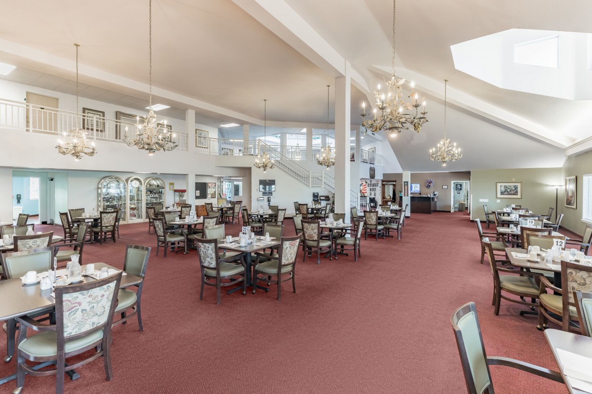 Spacious dining hall with elegant chandeliers and multiple seating arrangements.