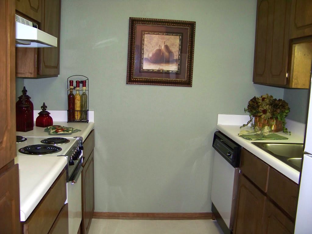 A cozy kitchen with wooden cabinets and a framed picture on the wall.