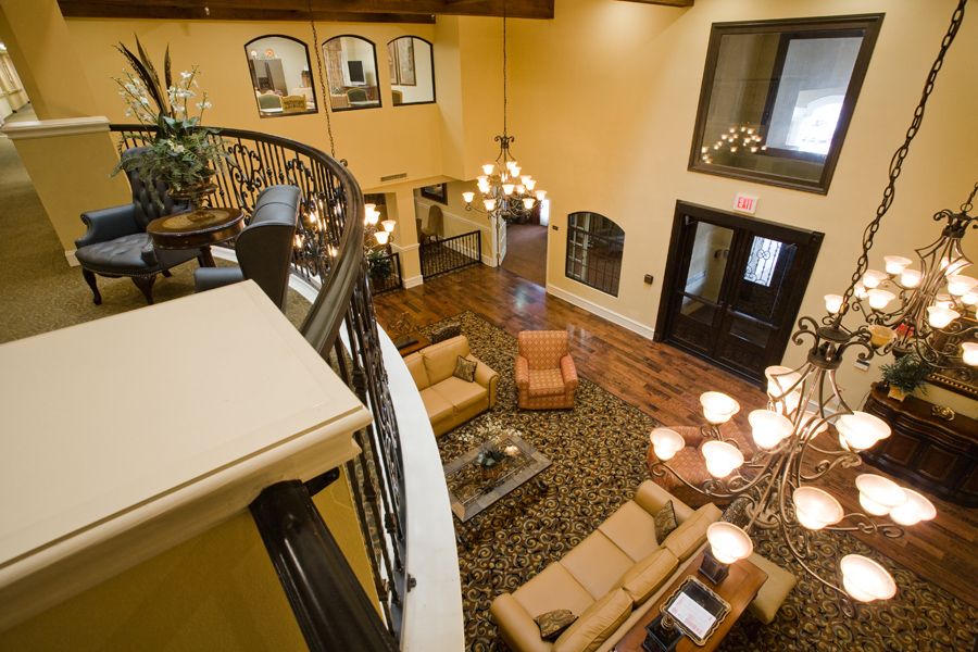 Spacious living room with a modern design, featuring a chandelier and comfortable seating area.