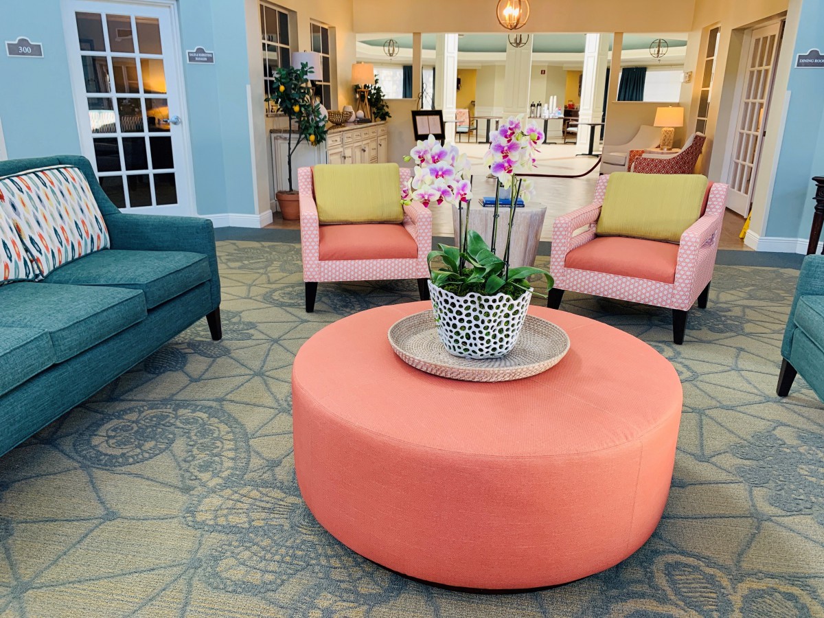 A modern lobby seating area featuring colorful furniture and decorative plants.
