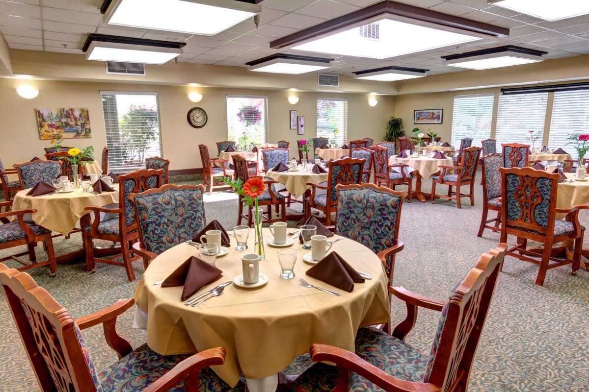 An elegantly set dining room with tables and chairs arranged for guests.