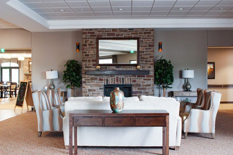 A cozy living room with a white sofa, brick fireplace, and elegant decor.