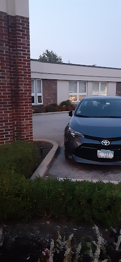 A black Toyota sedan parked beside a building.