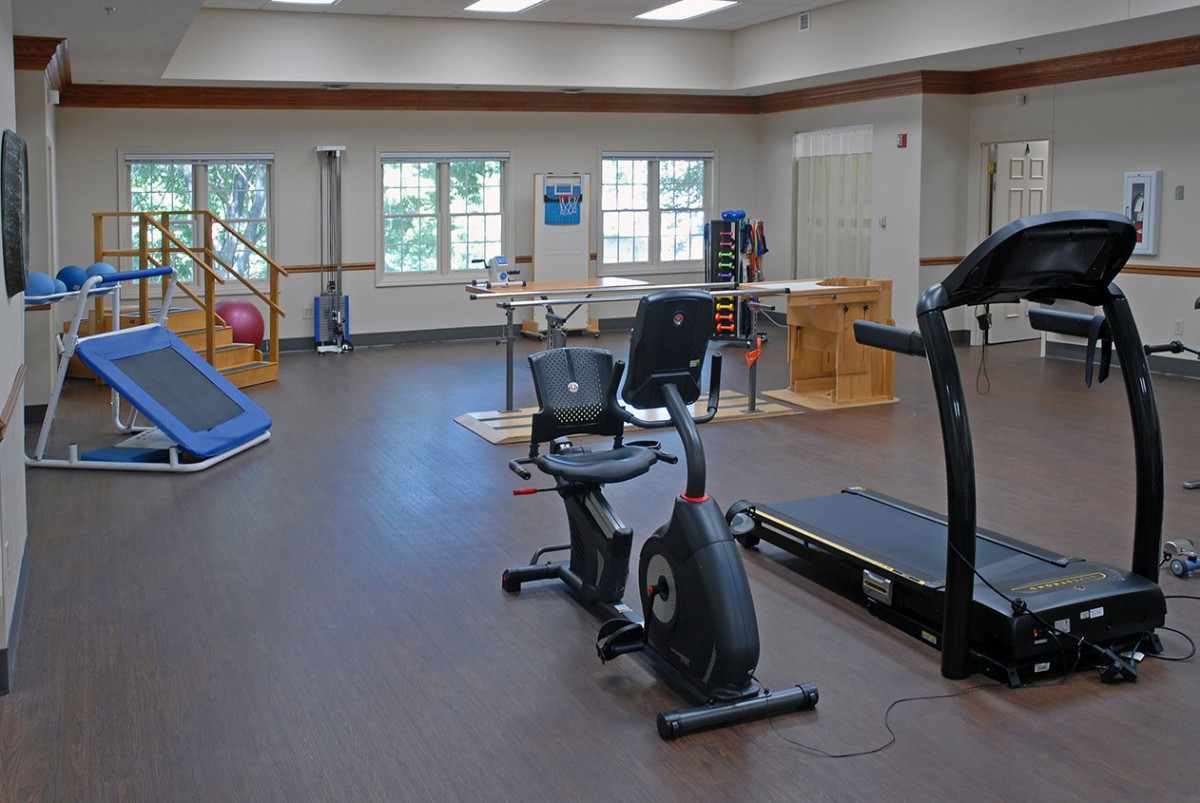 A rehabilitation center featuring various exercise equipment including a treadmill and stationary bike.