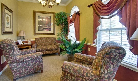 A traditional living room with patterned furniture and elegant decor.