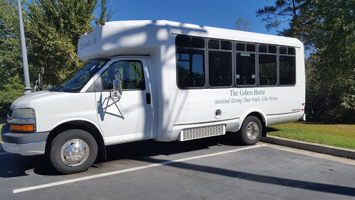 A white shuttle bus parked in a lot.