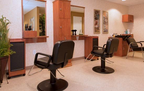 A well-lit salon featuring two styling chairs and mirrors.