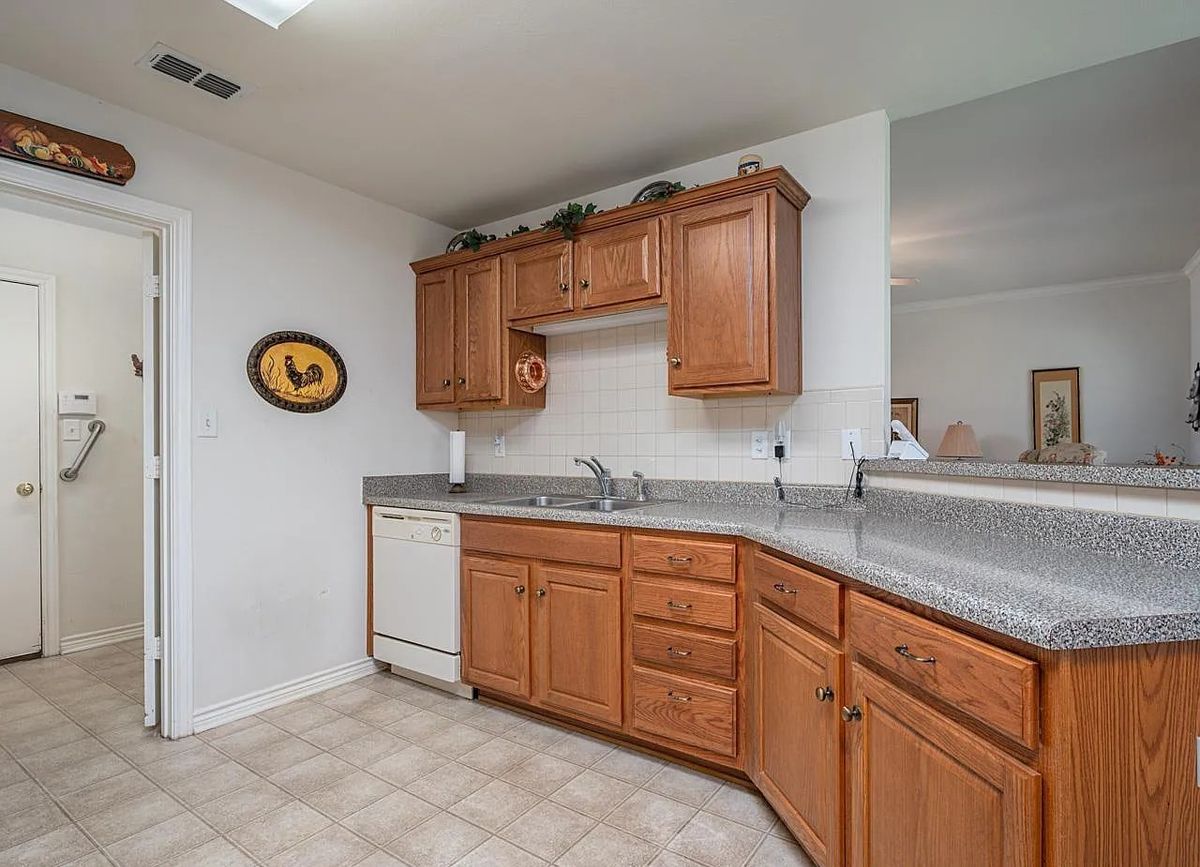 A cozy kitchen with wooden cabinets and a dishwasher under the counter.