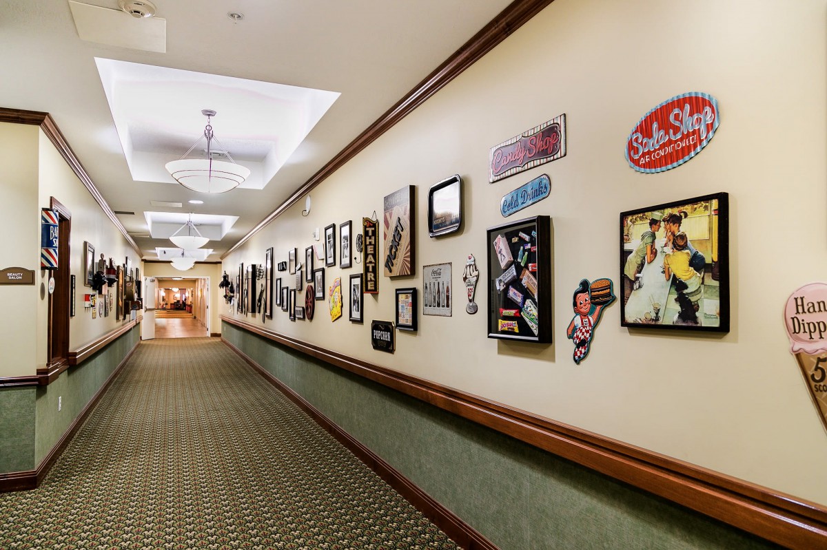 A hallway adorned with a variety of framed pictures and decorations on the walls.