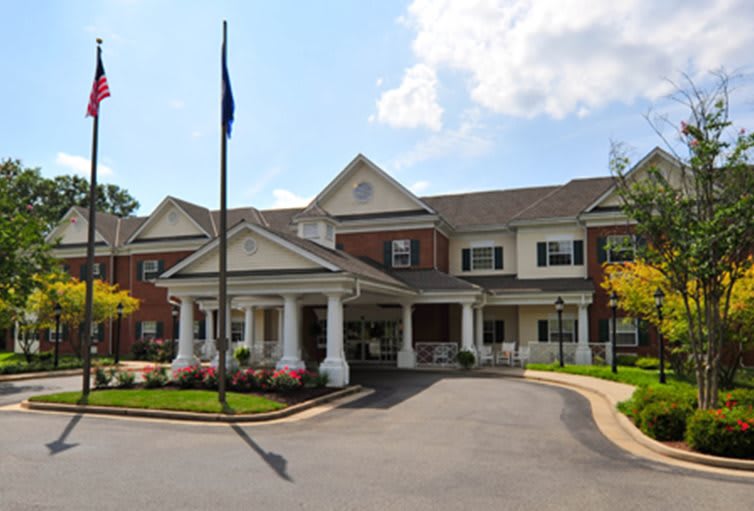 A well-maintained residential building with a covered entrance and landscaped surroundings.