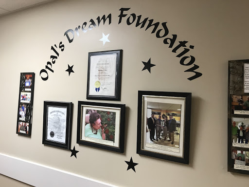A display featuring Opal's Dream Foundation with framed photos and certificates on the wall.