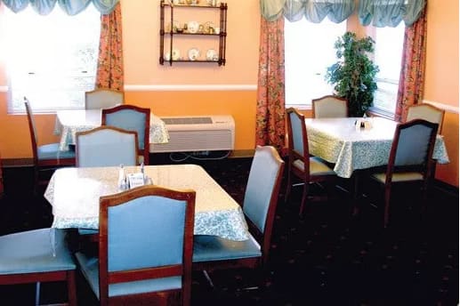 An empty restaurant dining area with neatly arranged tables and chairs.